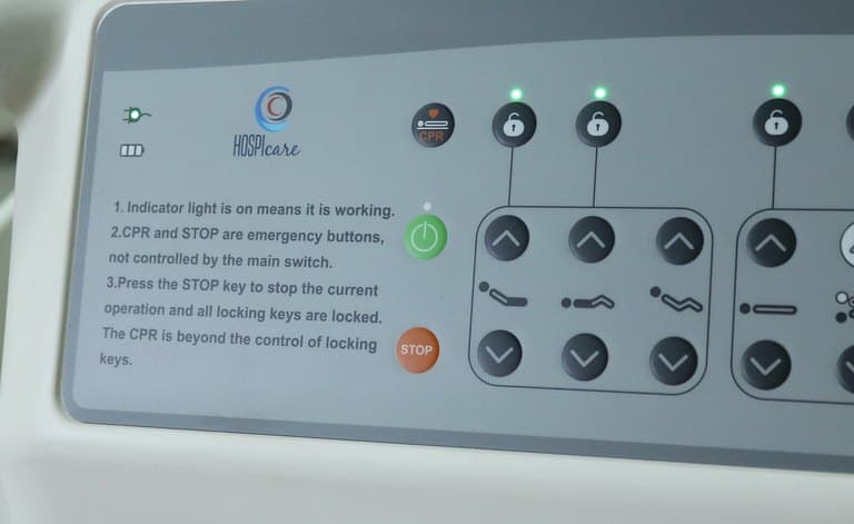 Santron Hospital Bed, close-up of rail control panel with CPR, lock keys and printed instructions