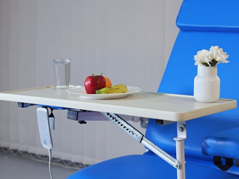 Over-seat table with a drink and fruit beside a HOSPIcare four-function hemodialysis chair — MLH-06I