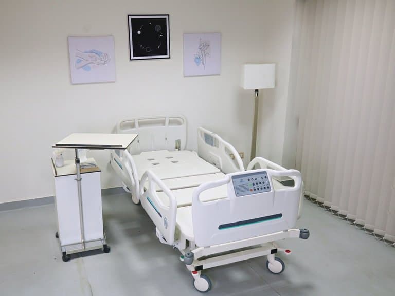 Lit de soins intensifs Santron en position plate dans une chambre équipée
