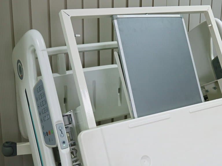 Tiroir à cassette radiographique sous le dossier du lit Santron avec le clavier de la barrière latérale, détail