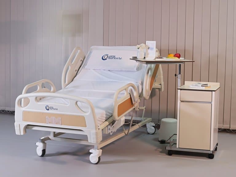 Lit PRIME care multifonctions dans une chambre de patient équipée d'une table de lit et d'une table de chevet — MLP-01
