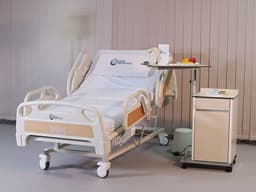 Lit PRIME care multifonctions dans une chambre de patient équipée d'une table de lit et d'une table de chevet — MLP-01