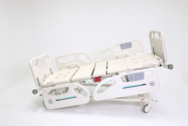 Santron Hospital Bed, side view with platform tilted, rails up, white studio