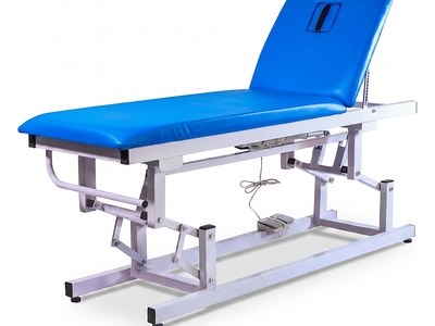 Electric Examination Couch, blue two-section top, backrest raised with face hole, foot switch, side studio view