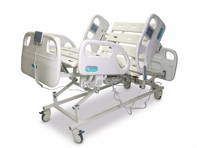 F5 Medical Bed, backrest raised, viewed from the foot corner with rails up, bare deck, white studio