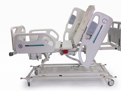 Santron Pro ICU Bed, backrest raised, rail control panels visible, side studio view