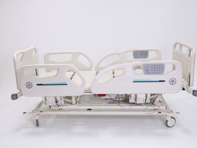 Santron Pro ICU Bed, side view flat with split side rails raised and rail control panels, white studio
