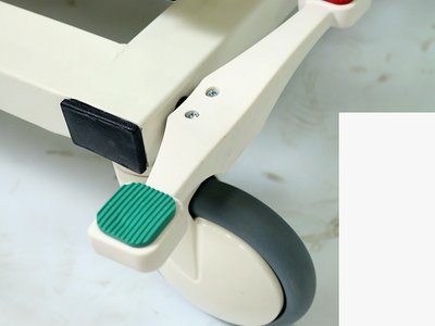 Santron Pro ICU Bed, close-up of central brake pedal with red and green pedals at the castor