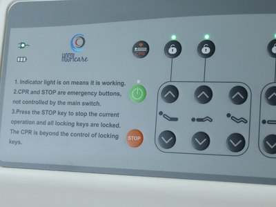 Santron Hospital Bed, close-up of rail control panel with CPR, lock keys and printed instructions